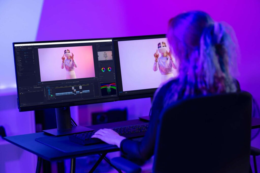 creative digital artist editing video at work amidst neon lights